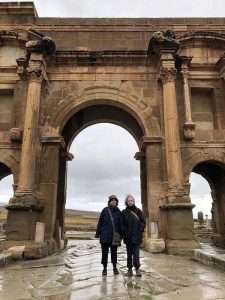 Mary standing in front of arch at Timgad archeological site